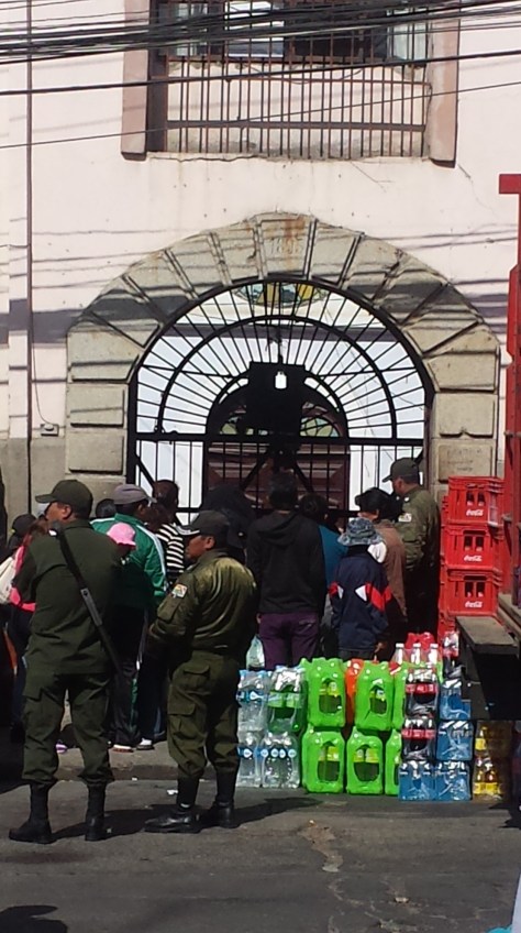 The delivery of drinks into San Pedro. Visitors also crowd around the front gate.